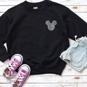 May include: Black sweatshirt with a white and black leopard print Mickey Mouse head design on the front.
