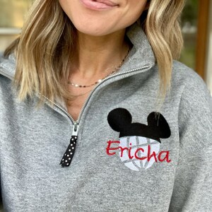 May include: Gray sweatshirt with a black and white Mickey Mouse head and a volleyball design. The name "Erica" is embroidered in red below the design.