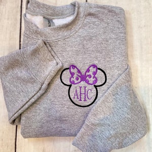 May include: Gray sweatshirt with a purple and white polka dot bow and black outline, with the letters AHC embroidered in black.