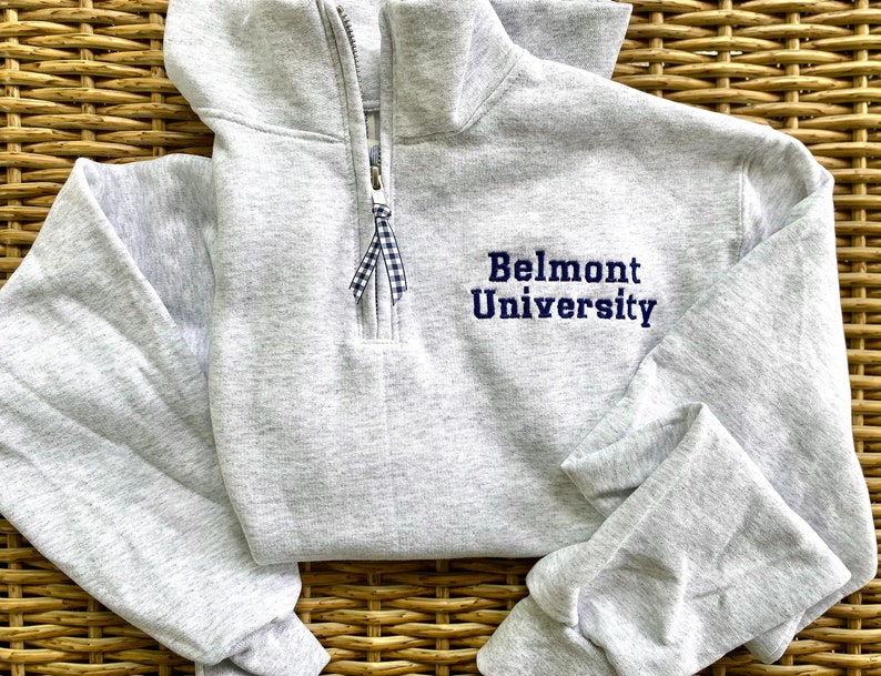 May include: A gray sweatshirt with a zipper and a navy blue embroidered logo that says "Belmont University".