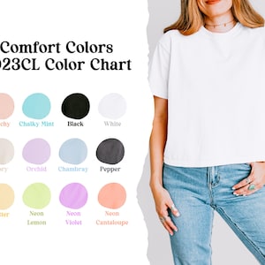 Peut inclure: Un t-shirt blanc Comfort Colors est pr&eacute;sent&eacute;, associ&eacute; &agrave; un jean bleu. L'image comprend un nuancier avec des teintes comme Peachy, Chalky Mint, Black et White. Le texte indique "Comfort Colors 3023CL Color Chart."