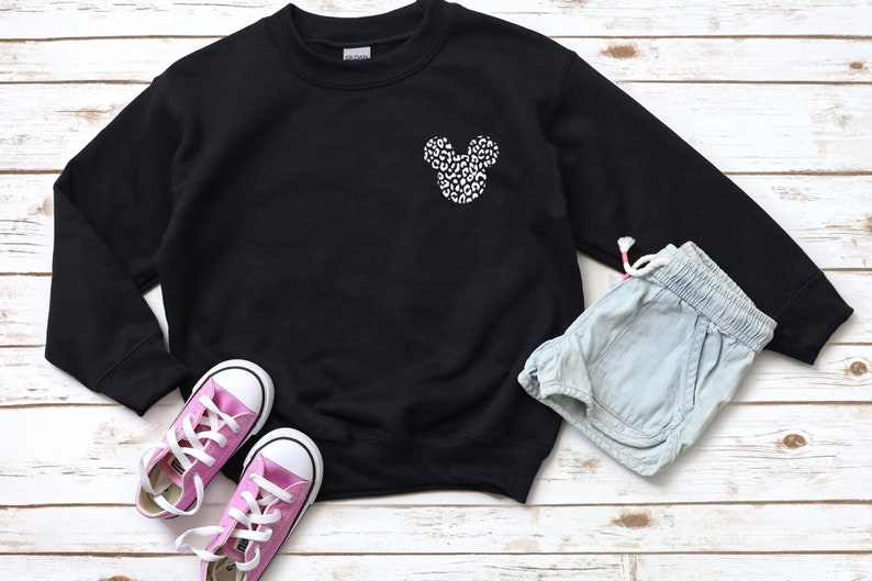 May include: Black sweatshirt with a white and black leopard print Mickey Mouse head design on the front.