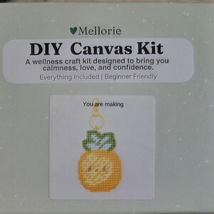 May include: A DIY Canvas Kit by Mellorie, designed for wellness. The kit includes everything needed to create a beginner-friendly project. The image shows a finished pineapple keychain. The text on the box reads "DIY Canvas Kit".