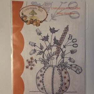 May include: A Crabapple Hill Studio embroidery pattern titled Halloween Thimble Bouquet by Meg Hawkey. The package features a line drawing of a pumpkin filled with thimbles, leaves, and the word BOO, enclosed in a clear plastic sleeve.