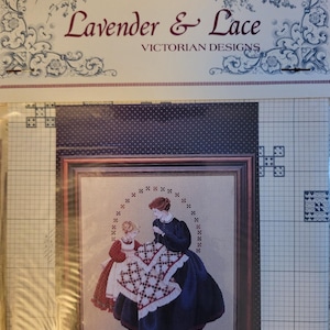 May include: A cross-stitch pattern titled "Lavender & Lace Victorian Designs" featuring a framed image of two women in Victorian dresses. The image shows a woman and a girl working on a quilt with a red and white pattern.