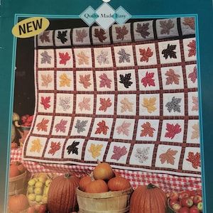 May include: A book titled "Appliqué Made Easy" with a quilt design featuring a patchwork of maple leaves in various colors and patterns. The book cover also includes the text "Quilts Made Easy" and "New".