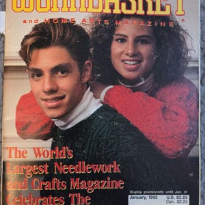 May include: The cover of the "Workbasket" magazine's special holiday issue. The magazine features a smiling man and woman. The text reads "The World's Largest Needlework and Crafts Magazine Celebrates The Holidays."