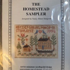 May include: A kit for a miniature needlepoint design called "The Homestead Sampler" by Nancy Bitzer Sturgeon. The design features a stitched image of a house, trees, and birds. The approximate size of the design is 2" x 1-1/2". The kit includes 40-ct. silk gauze, needle, and instructions.