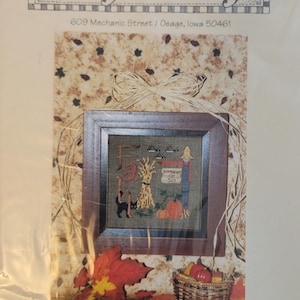 May include: Cross stitch pattern for a fall-themed design featuring a scarecrow, pumpkins, and the word "Fall". The pattern is titled "Pumpkins for Sale #009".