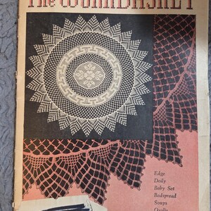 May include: The Workbasket magazine cover from January 1961. The cover features a black background with a white doily design and a pink and black lace pattern. The magazine's title is in red and black letters. The cover also lists projects like a baby set and bedspread.