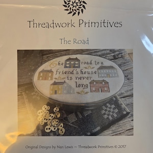 May include: A cross-stitch kit titled "The Road" by Threadwork Primitives. The kit features a stitched design of houses with the text "the road to a friend's house is never long". The kit includes a needlework hoop and other supplies.