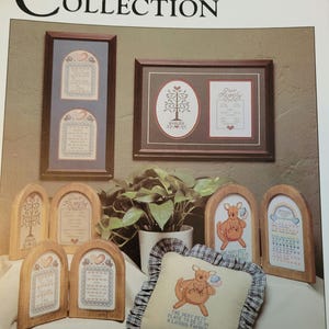 May include: The Cornell Collection features framed cross-stitch art and a decorative pillow. The framed pieces include family trees, quotes, and heart designs. The pillow has a kangaroo design and the text "THE VERY BEST PLACE TO BE IS IN A LOVING FAMILY."
