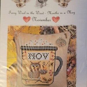 May include: Cross stitch pattern for a mug with an owl and the word "NOV" for November. The pattern is part of a series called "Fairy Wool in the Wood - Months in a Mug".