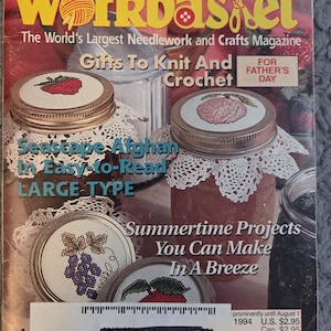 May include: A vintage issue of "Workbasket" magazine featuring needlework and crafts projects. The cover showcases cross-stitch designs on jar lids, with text including "Gifts To Knit And Crochet" and "Summertime Projects You Can Make In A Breeze."
