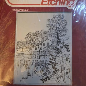 May include: A Bucilla Needle Etching kit featuring a black and white illustration of a water mill scene. The kit includes a picture panel with a cut size of 18x22 inches. The kit is labeled "WATER MILL".