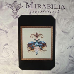 May include: A Mirabilia cross-stitch pattern featuring a detailed design of a woman in a blue gown with ornate embellishments. The artwork is framed in gold and set against a background with the text "Mirabilia cross-stitch".