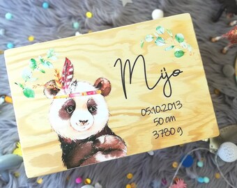 May include: Wooden box featuring a panda bear wearing a headband with feathers. The box is decorated with green leaves and the name "Mijo" is written on the front. The date "05.10.2013", "50 cm", and "3780 g" are also written on the box.
