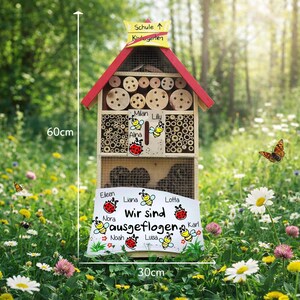May include: A wooden insect house, 60cm tall and 30cm wide, with a red roof and multiple compartments for insects. The house has a sign that says "Wir sind ausgeflogen" and includes names. The house is in a garden.