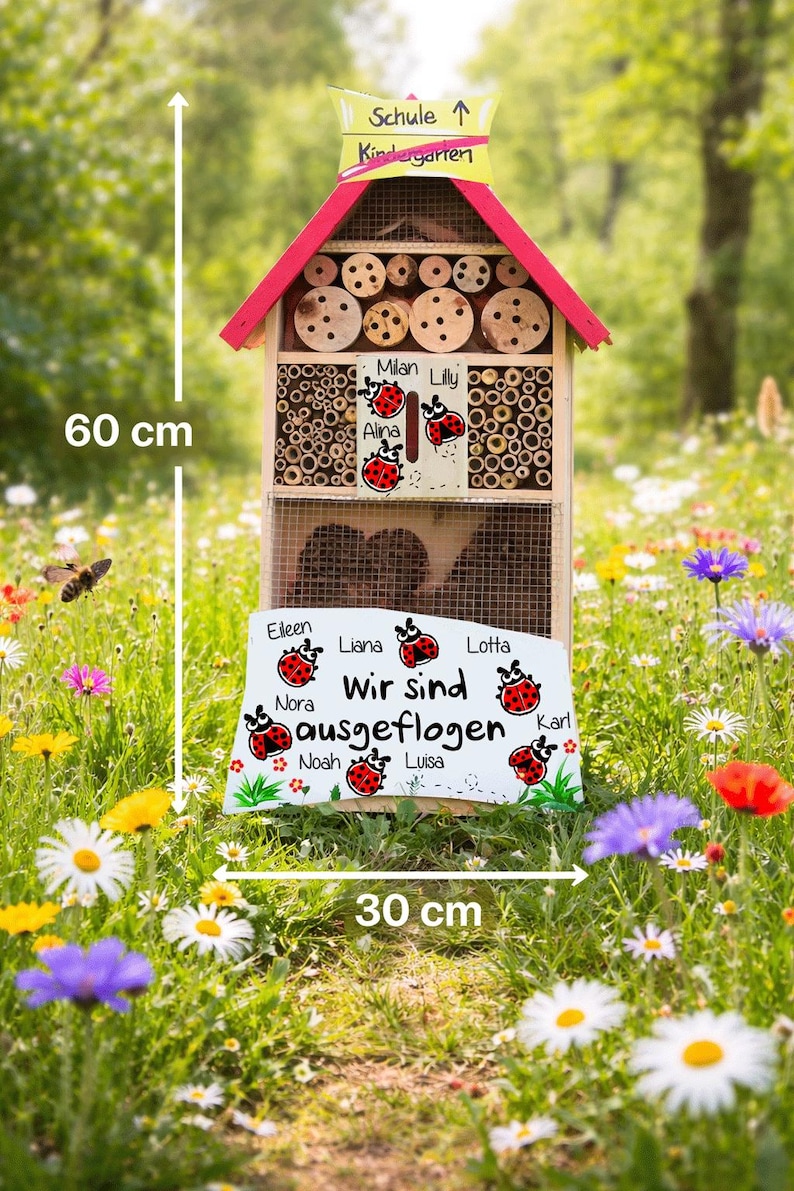 May include: A wooden insect hotel, 60 cm tall and 30 cm wide, with a red roof and a sign that says "Kindergarten". The hotel is filled with various natural materials and has a sign with names and ladybug illustrations. The text "Wir sind ausgeflogen" is also visible.