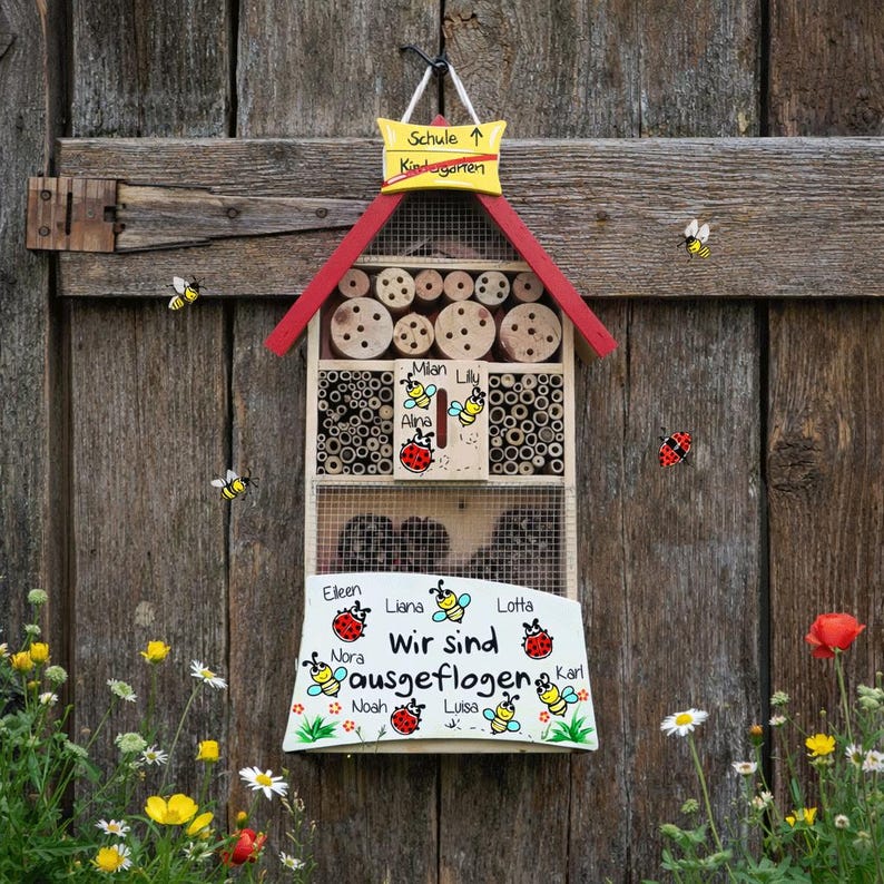 May include: A wooden insect hotel with a red roof and a sign that says "Schule Kindergarten". The hotel is decorated with bees, ladybirds, and the words "Wir sind ausgeflogen". The hotel is hanging on a wooden wall.