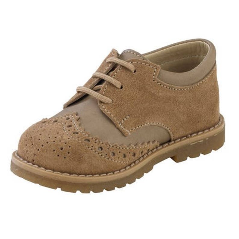 May include: Tan leather brogue shoes with laces. The shoes have a wingtip design and a rubber sole.