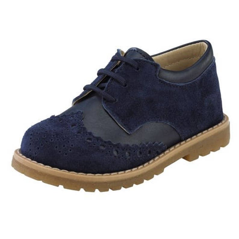 May include: Navy blue suede leather oxford shoes with a lace-up closure and a brogue design.