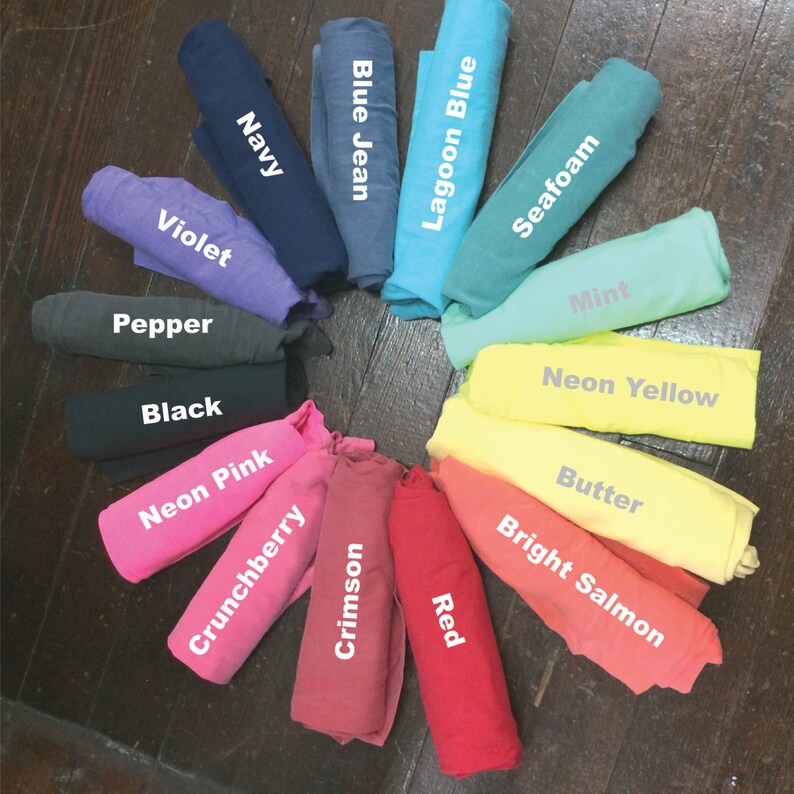 May include: A colour chart of fabric swatches rolled up in a circle. The colours are: Navy, Blue Jean, Lagoon Blue, Seafoam, Mint, Neon Yellow, Butter, Bright Salmon, Red, Crimson, Crunchberry, Neon Pink, Black, Pepper, Violet.