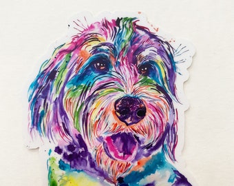 May include: A colorful watercolor painting of a dog's face. The dog has a white face with pink, purple, blue, green, and yellow accents. The dog's tongue is sticking out. The sticker is 3 inches in diameter.