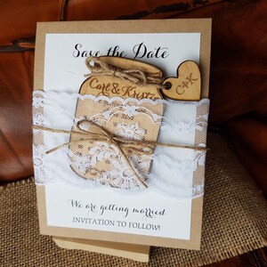 May include: A rustic wedding invitation with a wooden jar and heart embellishments. The invitation features the text "Save the Date" and "Carl & Kristin". It is decorated with white lace and twine, with the text "We are getting married, INVITATION TO FOLLOW!"