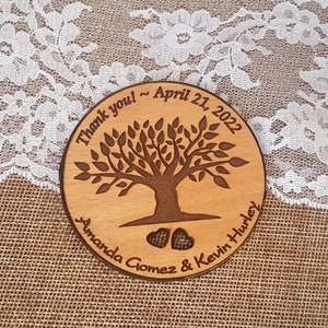 May include: A round wooden sign with a tree design and the text "Thank you - April 21, 2022 Amanda Gomez & Kevin Hurley".