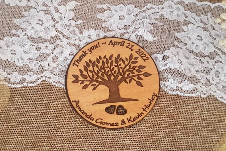 May include: A round wooden sign with a tree design and the text "Thank you - April 21, 2022 Amanda Gomez & Kevin Hurley".