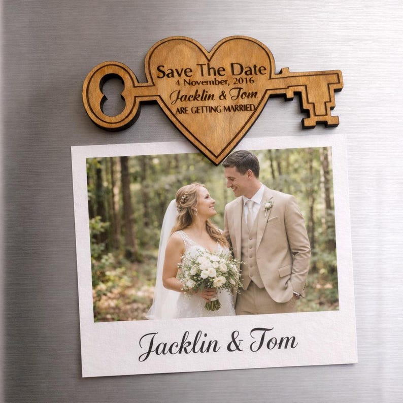 May include: A wooden heart-shaped key with the text "Save The Date" and wedding details. Below, a photo of a couple, with the names "Jacklin & Tom" at the bottom. The key and photo are displayed on a metallic surface.