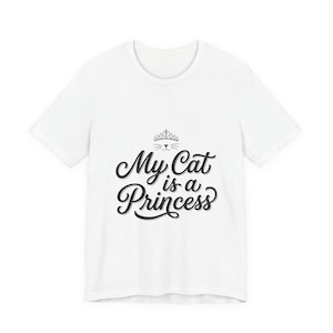 Puede incluir: Camiseta blanca con la frase "My Cat is a Princess" en fuente negra. Encima del texto, una cara de gato con una corona. Una prenda casual para el uso diario.