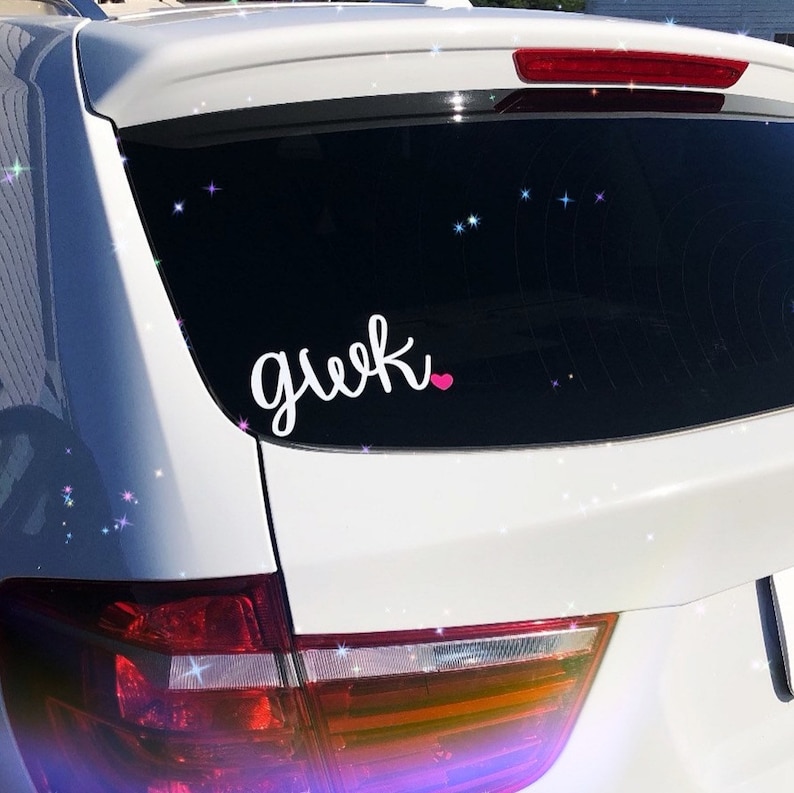 Pode incluir: Carro branco com um vidro traseiro preto. O vidro tem um adesivo de vinil branco que diz "geek" com um cora&ccedil;&atilde;o rosa.