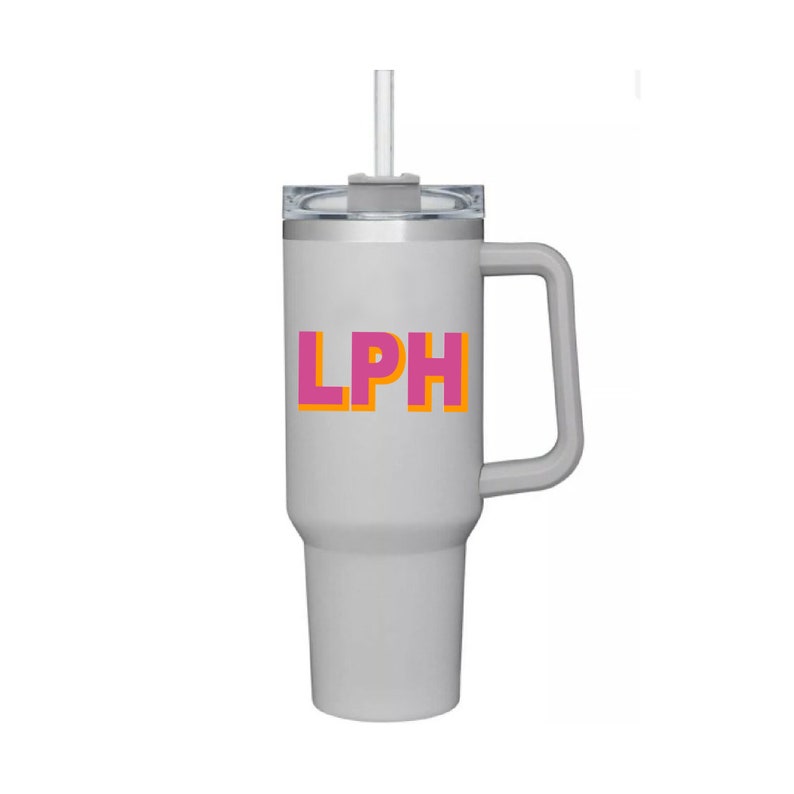 May include: A gray stainless steel travel mug with a black lid and a handle. The mug has a pink and orange "LPH" logo on the front.