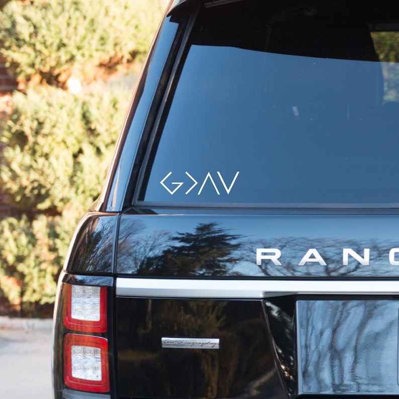 May include: A black car with a white "God is Greater Than" decal on the back window.