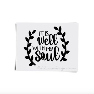 May include: Black and white typography design with a wreath of leaves around the text "It is well with my soul".