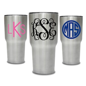 May include: Three stainless steel tumblers with personalized monograms. The first tumbler has the monogram "LKS" in pink, the second tumbler has the monogram "KSE" in black, and the third tumbler has the monogram "MAS" in blue.
