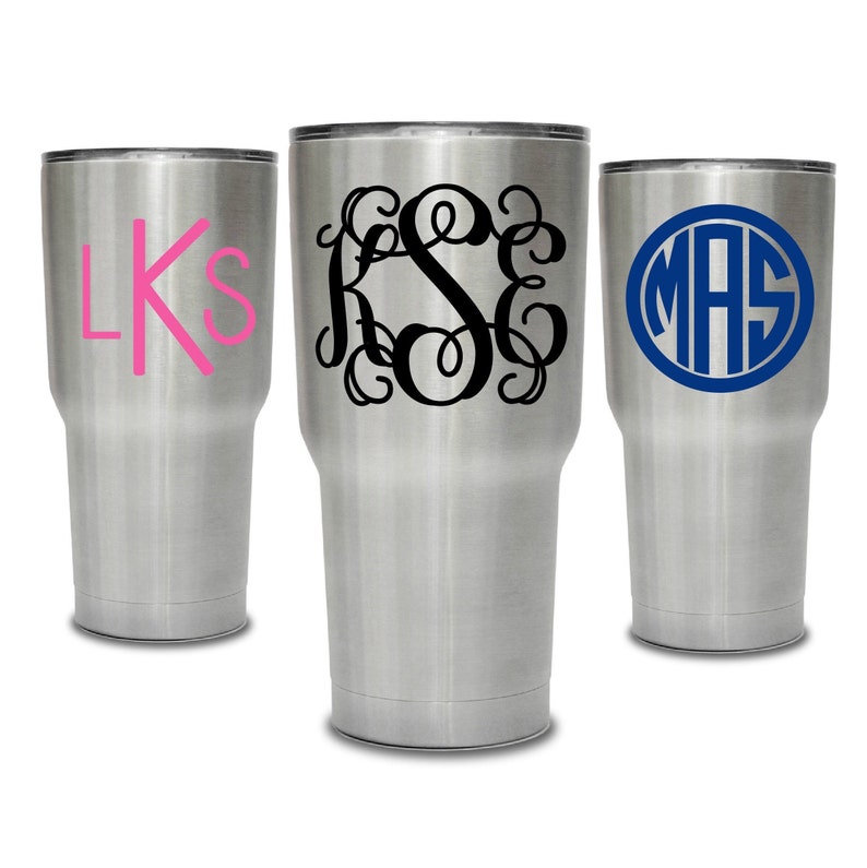 May include: Three stainless steel tumblers with personalized monograms. The first tumbler has the monogram "LKS" in pink, the second tumbler has the monogram "KSE" in black, and the third tumbler has the monogram "MAS" in blue.