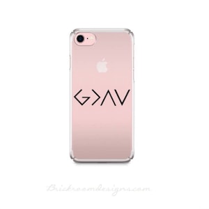 May include: A clear phone case with a pink background and a black graphic of the symbol "G>A<" on the back.