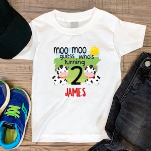 May include: White t-shirt with a graphic of two cows and the text "Moo Moo guess who's turning 2 JAMES".