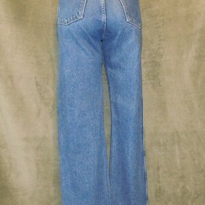 May include: Light blue denim jeans with a classic five-pocket design. The jeans have a straight leg fit and a brown leather patch with the brand name on the back. The jeans are made of a durable denim fabric.