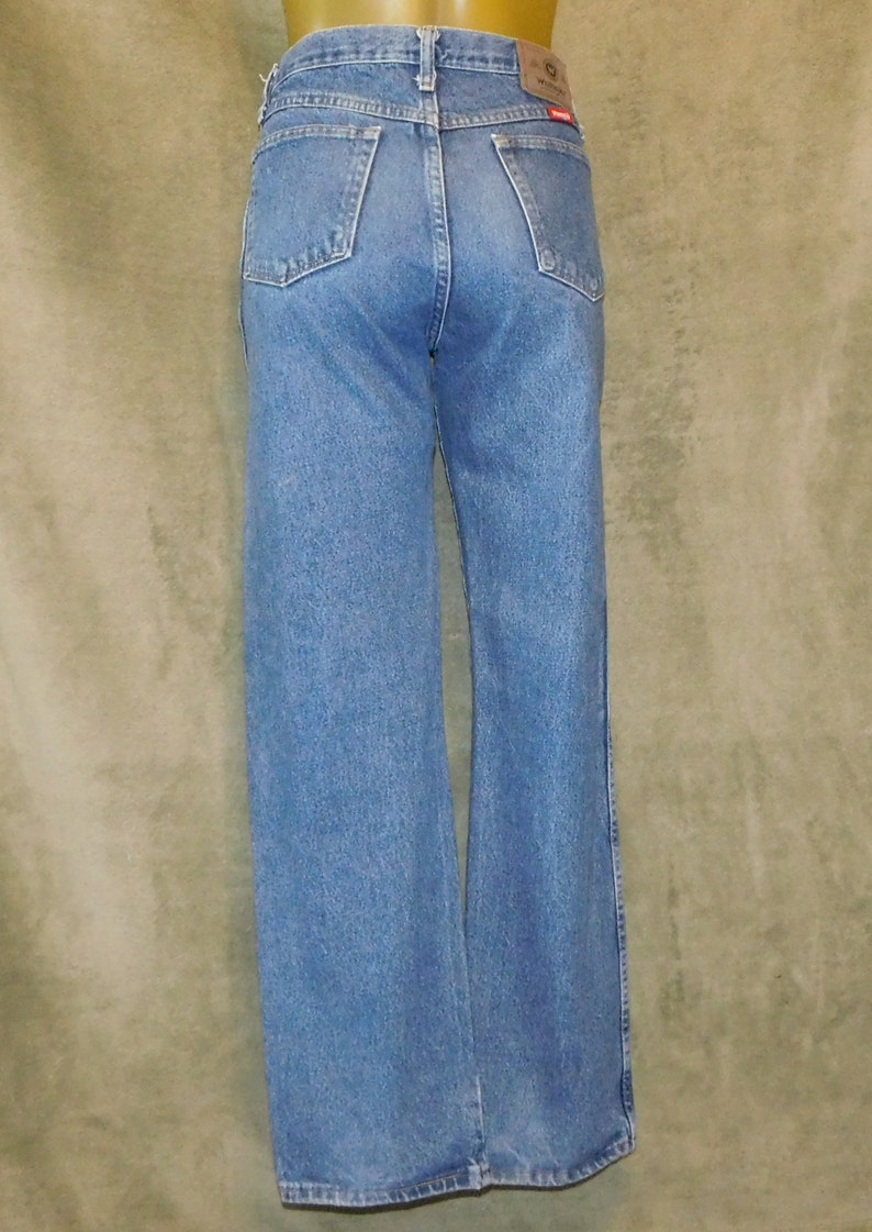 May include: Light blue denim jeans with a classic five-pocket design. The jeans have a straight leg fit and a brown leather patch with the brand name on the back. The jeans are made of a durable denim fabric.