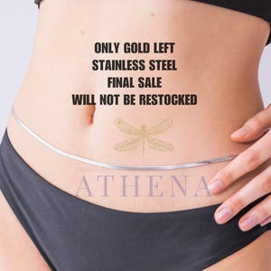 May include: A silver-colored body chain worn around the waist. The image also displays the text "ONLY GOLD LEFT, STAINLESS STEEL, FINAL SALE, WILL NOT BE RESTOCKED" and the brand name "ATHENA". The model is wearing black underwear.