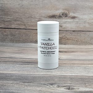 May include: White deodorant stick with a black label that reads "Naturestic Vanilla & Patchouli Natural Deodorant Baking Soda Free Net wt. 2.6 oz."