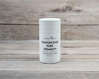 May include: White deodorant stick with the text "Naturistic Frankicense Rose Geranium Natural Deodorant Baking Soda Free Net wt. 1.3 oz."