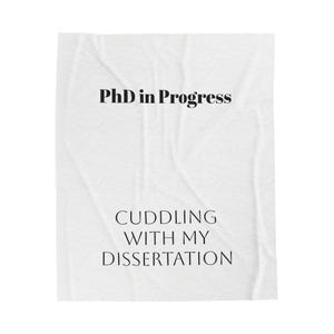 May include: White poster with black text that reads "PhD in Progress CUDDLING WITH MY DISSERTATION".