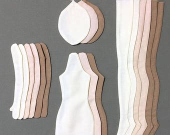 May include: A set of fabric doll-making patterns in various shades of brown, pink, and white. The patterns include pieces for the head, body, and legs.