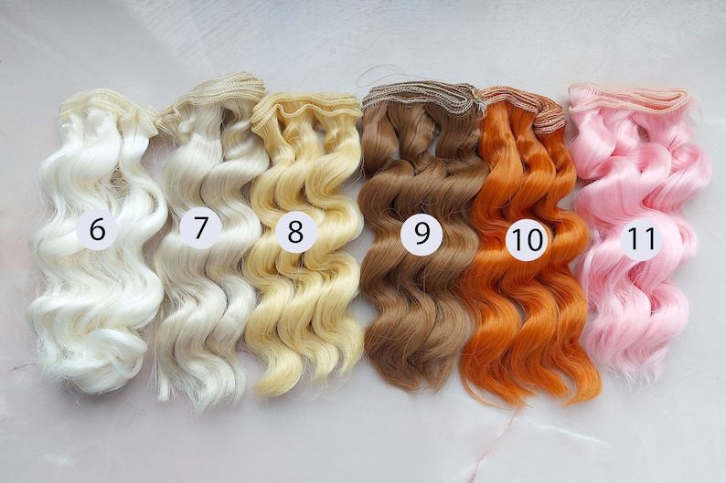 Puede incluir: Seis mechones de pelo de mu&ntilde;eca en varios colores, incluyendo blanco, rubio, marr&oacute;n, naranja y rosa. Los mechones son ondulados y tienen un dise&ntilde;o de clip. Los mechones est&aacute;n numerados del 6 al 11.