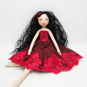 Interior rag doll with long black hair in a red dress